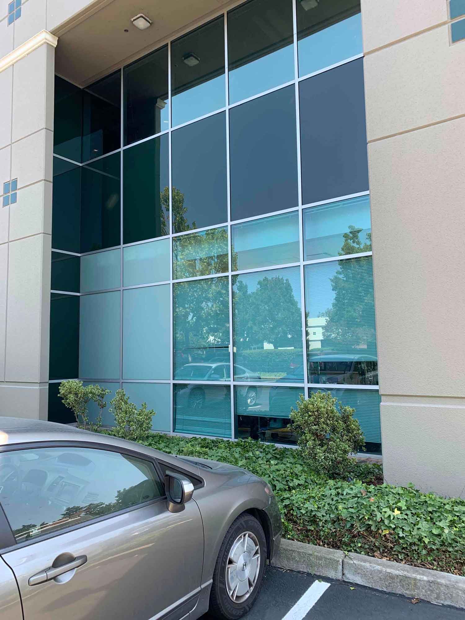 Side view of a commercial building in Hayward with sun control window film on ground floor windows.