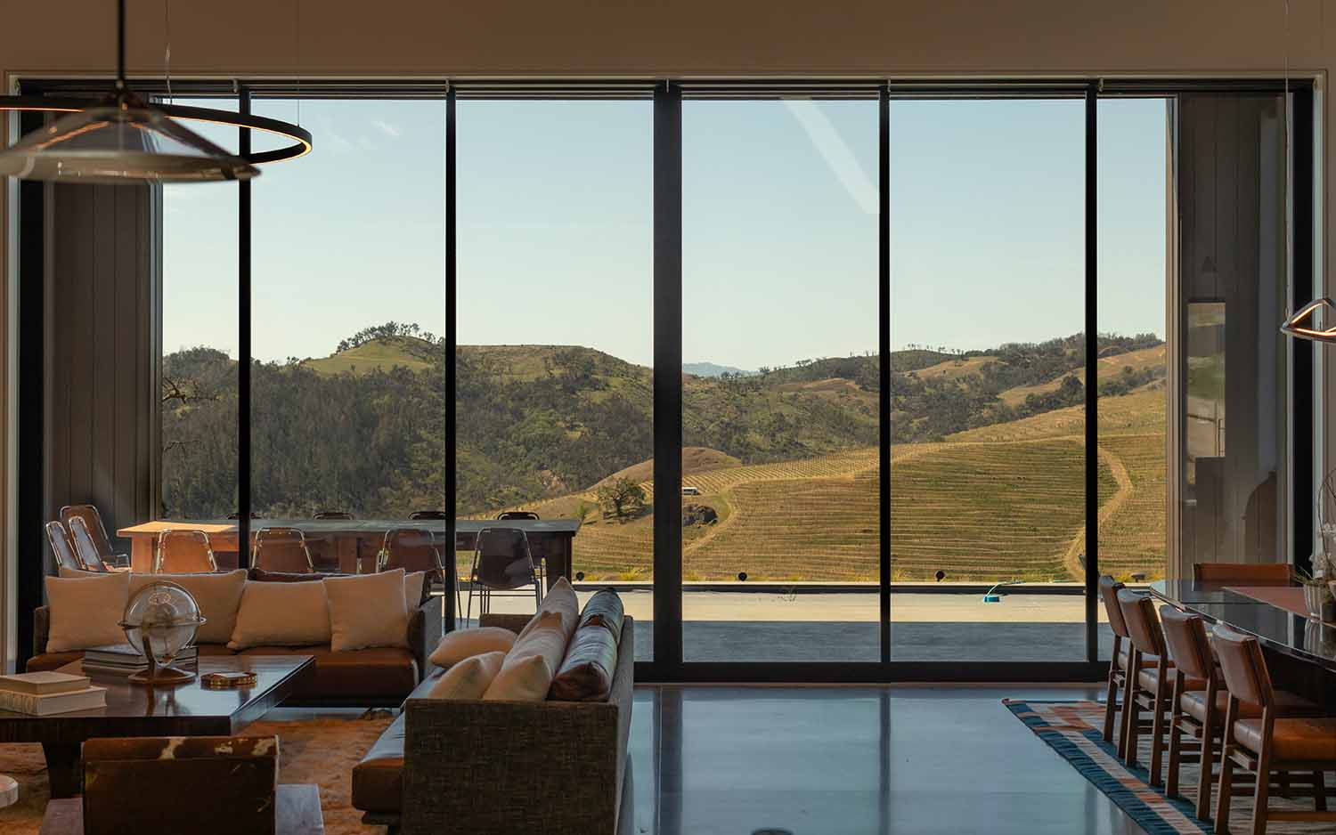 Interior view of a modern living space in the San Francisco Bay Area with 3M solar window film, overlooking vineyard hills.